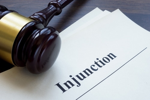 An image conveying the subject of injunctions, the image being A document with the word Injunction, and a gavel